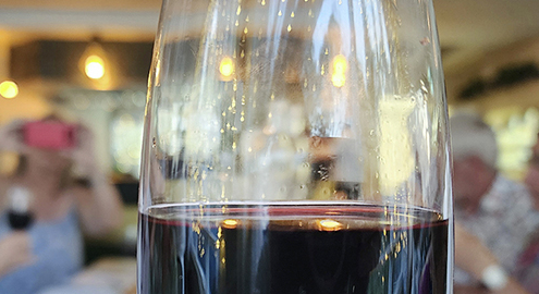 A taste of Italy - a glass of red wine and people wine tasting