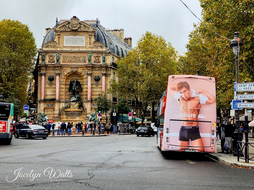 Insights: Bus with ad beside a historic monument in Paris.