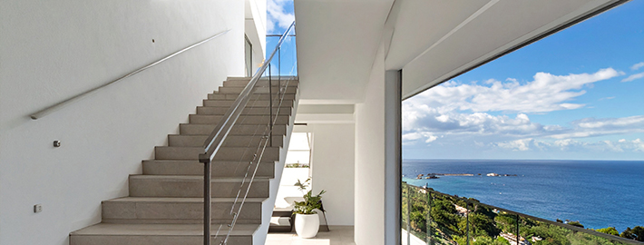 Architectural interior staircase with ocean views in a coastal Mater Lotteries prize home