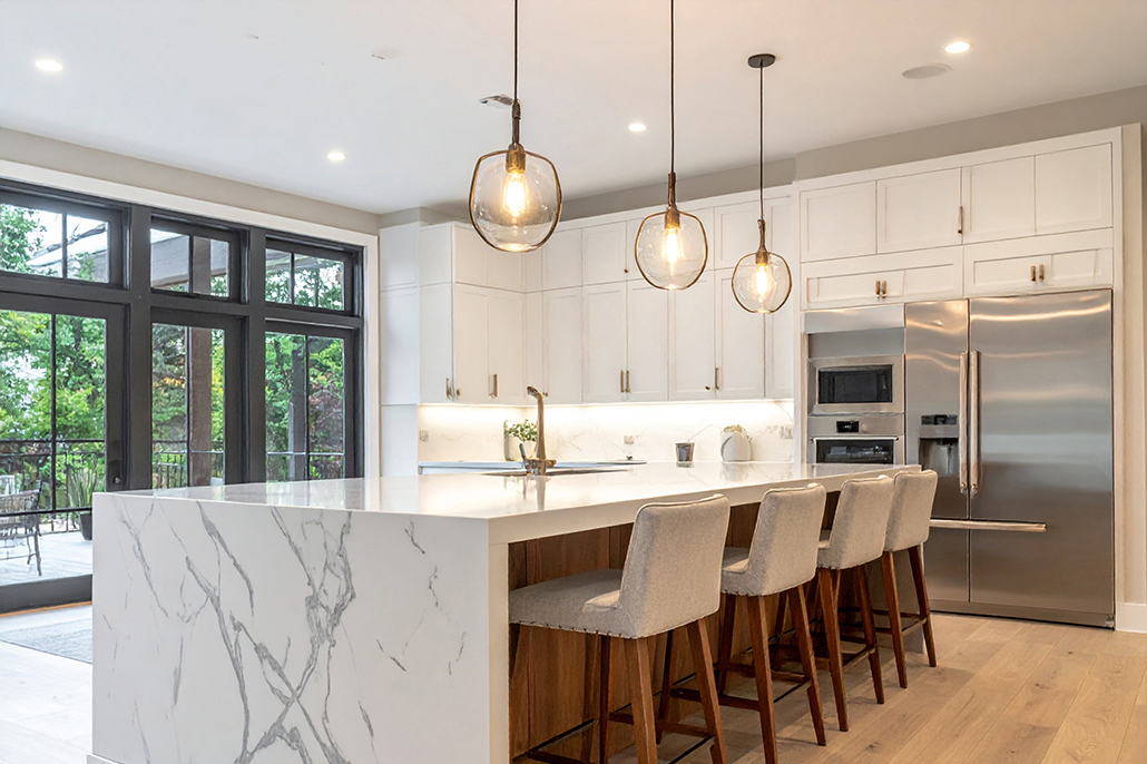 Modern open-plan kitchen with stone island and pendant lighting inside a Mater Lotteries prize home