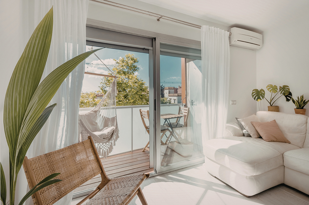 Townhouse living: Small apartment balcony with hammock and plants in a bright townhouse setting