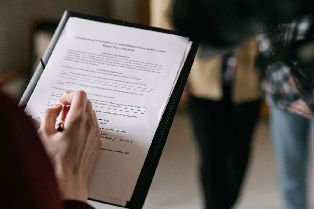 Person completing a body corporate maintenance checklist to report property issues