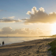 retreat accommodation hervey bay: A peaceful sunrise over Hervey Bay, where still waters and scattered sailboats capture the region’s laid-back coastal charm.