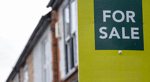 For Sale sign outside a townhouse complex during a property inspection