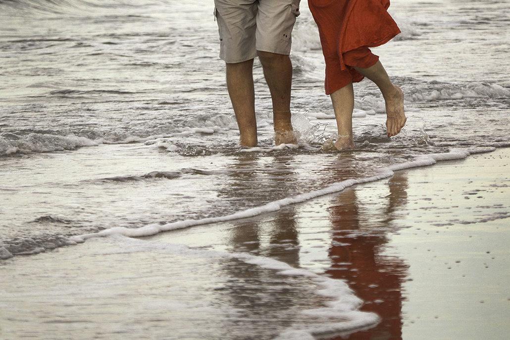 People walking along Hervey Bay beach shoreline Queensland coastal lifestyle