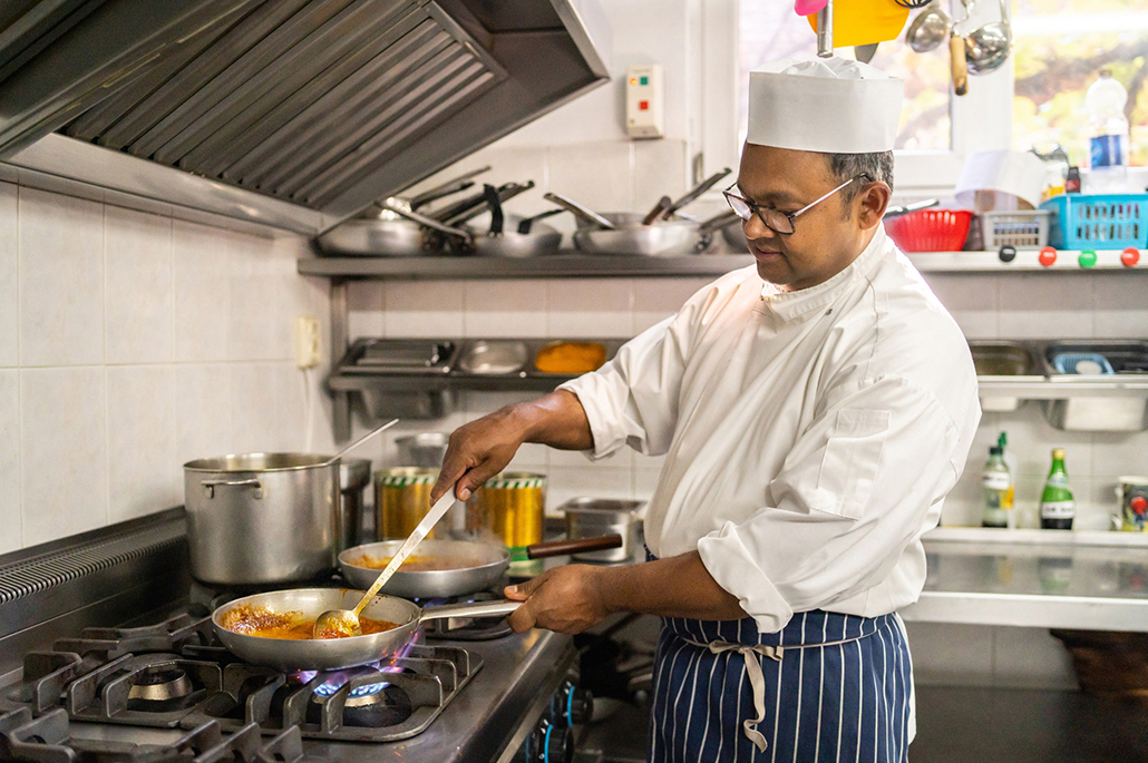 Chef cooking curry in a commercial Indian kitchen