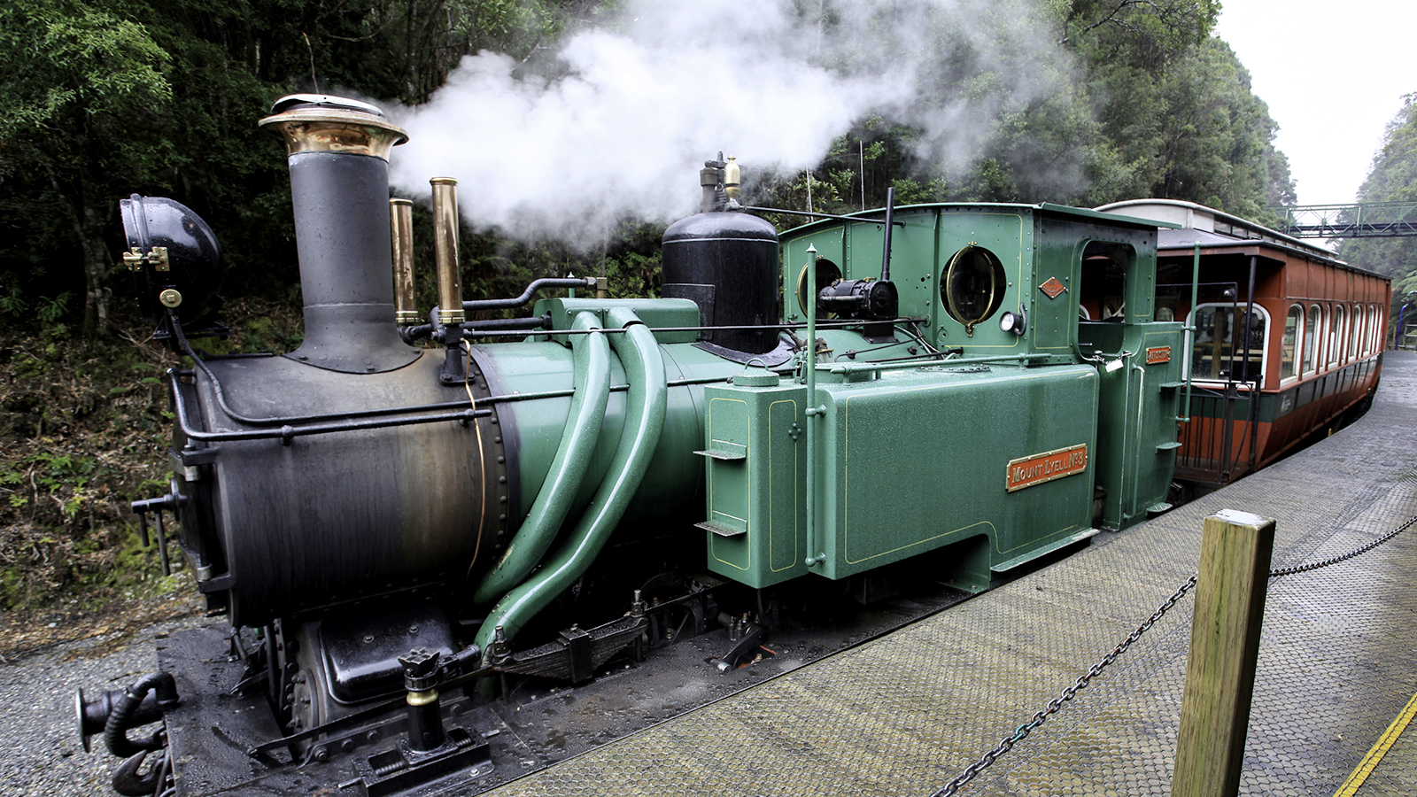Explore Travel: Heritage steam locomotive on the West Coast Wilderness Railway surrounded by rainforest in Tasmania.