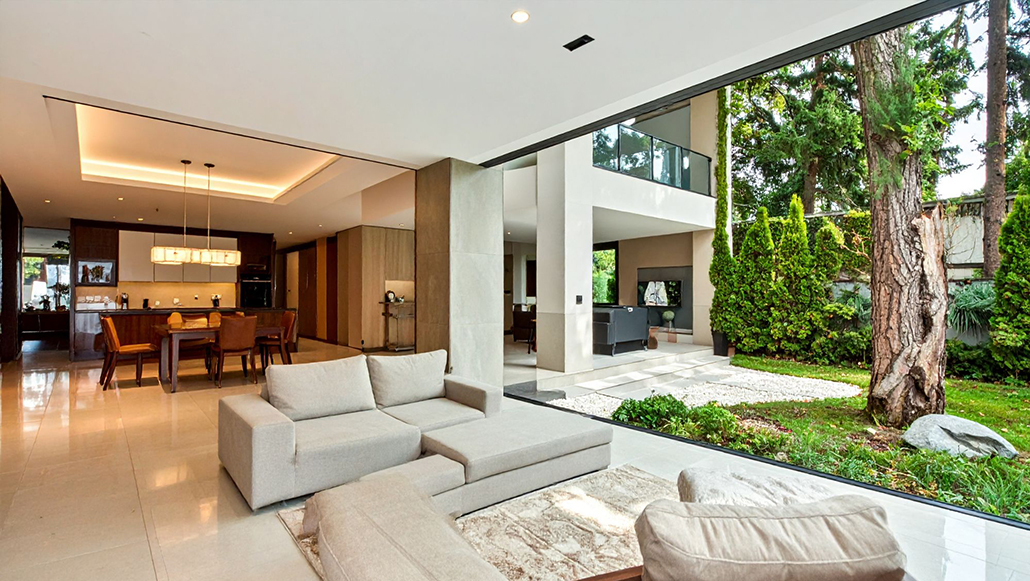 Queensland coastal living: Contemporary living room opening directly onto a lush green garden